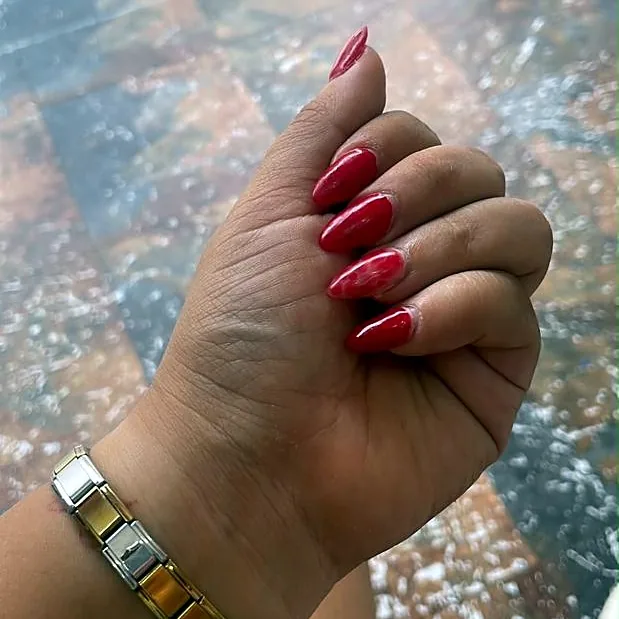 Hand with long almond nails in glossy red